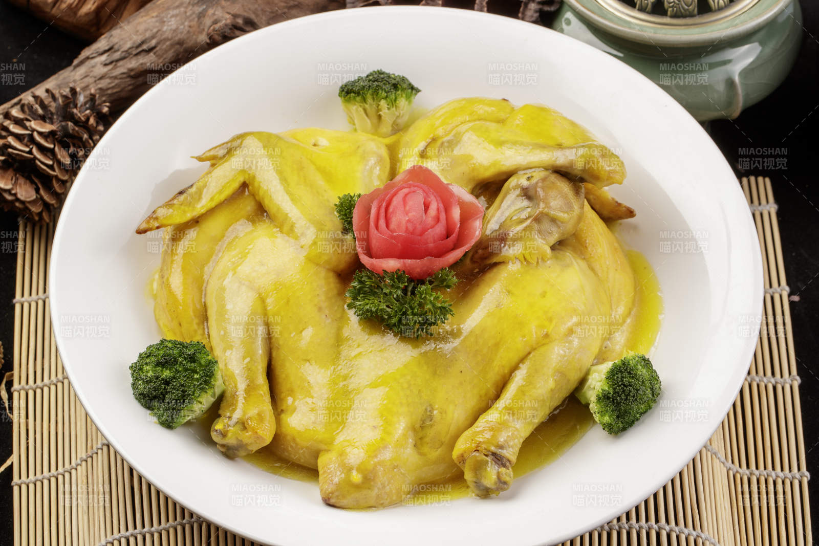 圆形瓷盘装的清蒸三黄鸡摆放在寿司帘上图片