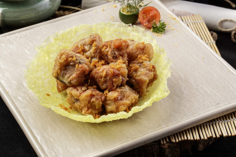 米色放瓷盘装的金盏猪小排摆放在寿司帘上图片