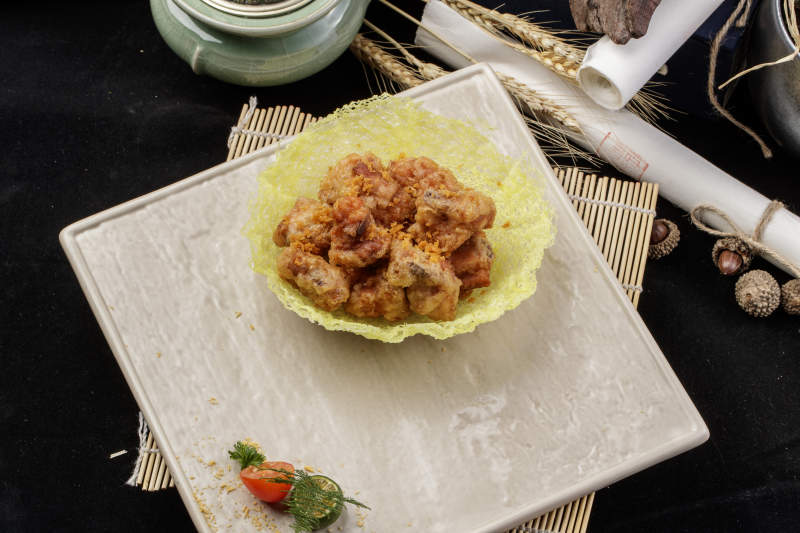 米色放瓷盘装的金盏猪小排摆放在寿司帘上图片