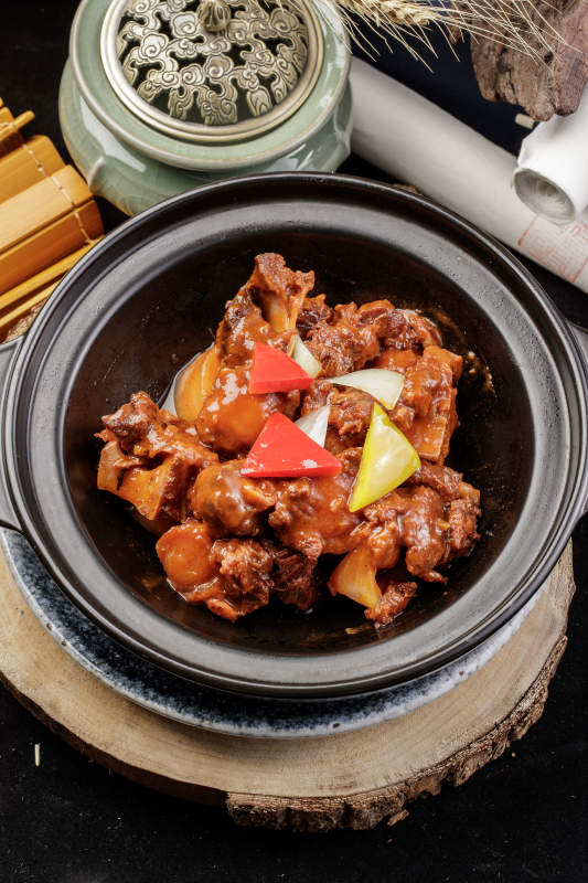 黑色砂锅装的黄焖牛尾图片