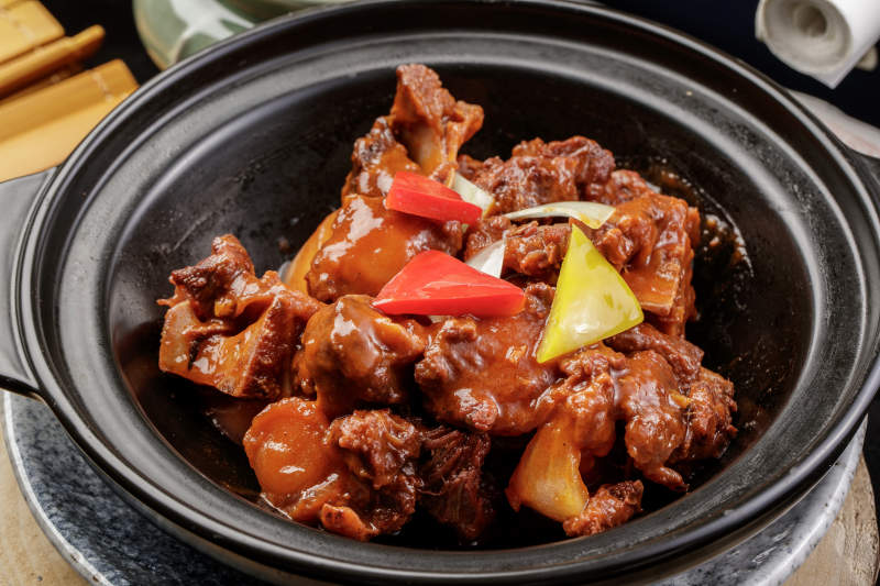 黑色砂锅装的黄焖牛尾图片