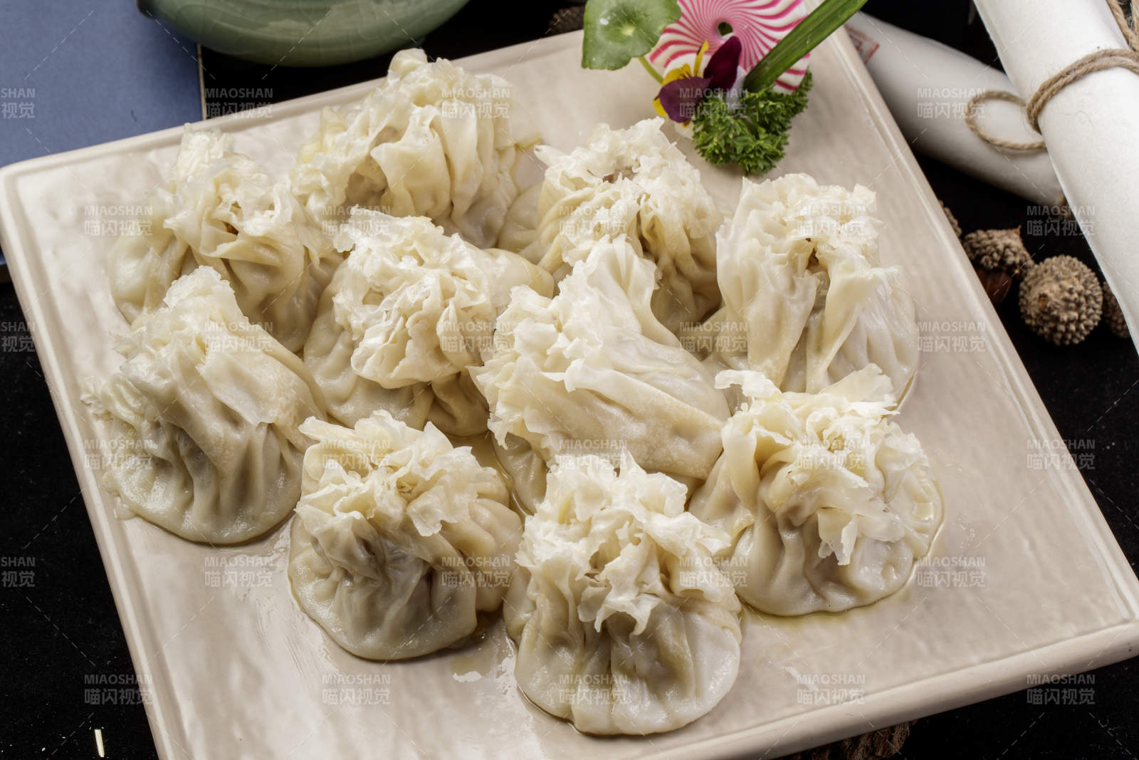 米色瓷盘装的美味烧麦摆放在黑色背景上图片