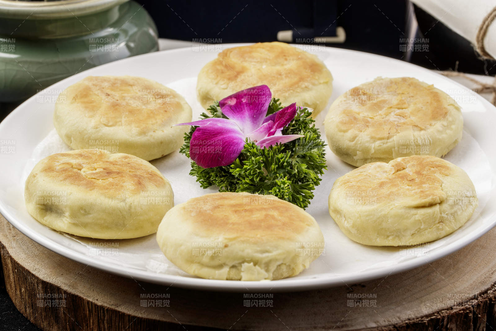 圆形瓷盘装的咸鱼酥饼摆放在樟木砧板上图片