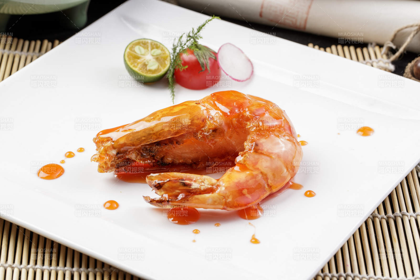 方形瓷盘装的油煎浇汁深海虾摆放在寿司帘上图片