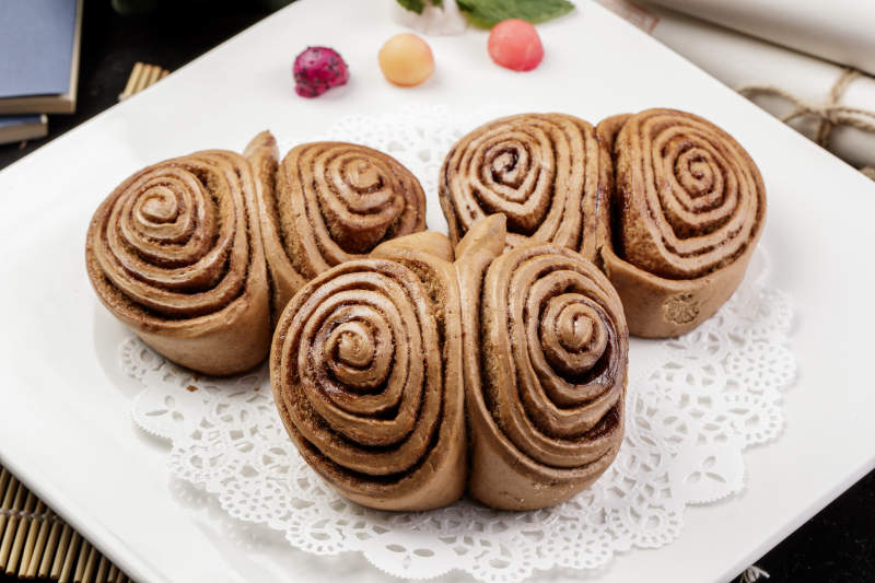 白色瓷盘装的黑豆面肉龙卷图片