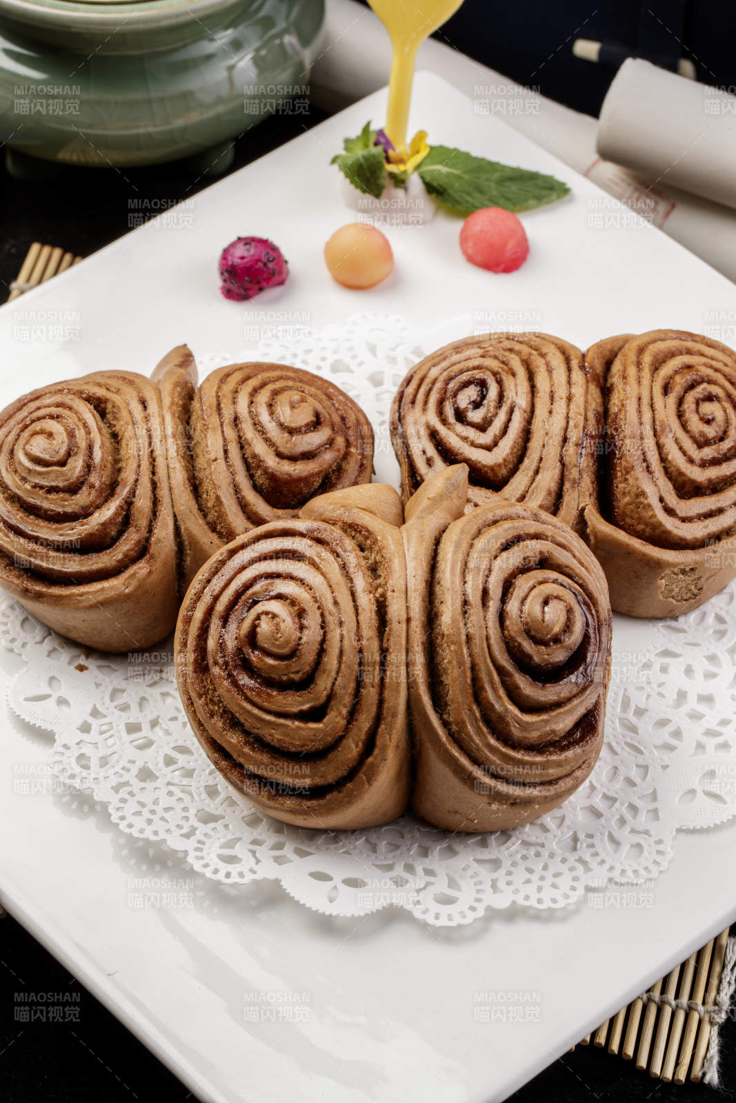 白色瓷盘装的黑豆面肉龙卷图片