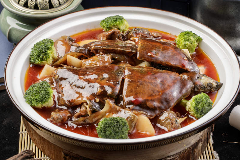 白瓷大圆盘装的浓汤炖甲鱼摆放在寿司帘上图片