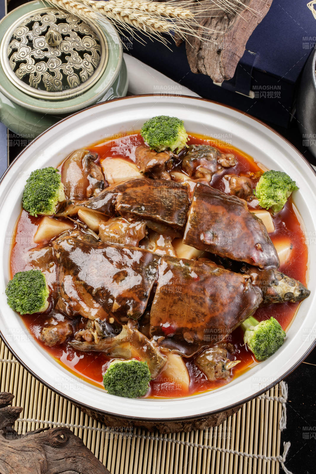白瓷大圆盘装的浓汤炖甲鱼摆放在寿司帘上图片