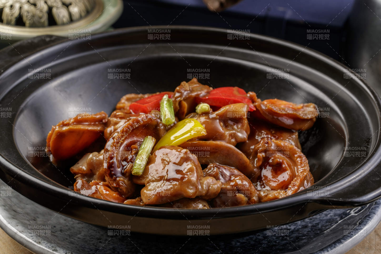 黑色砂锅装的砂锅鲍鱼鸡块摆放在樟木砧板上图片