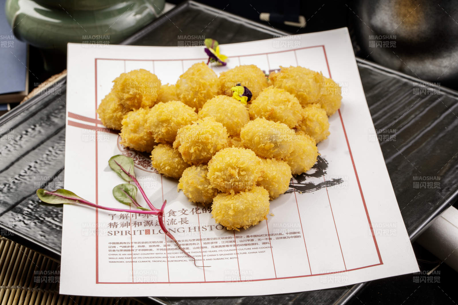 黑色石盘装的油炸苏式小汤圆图片