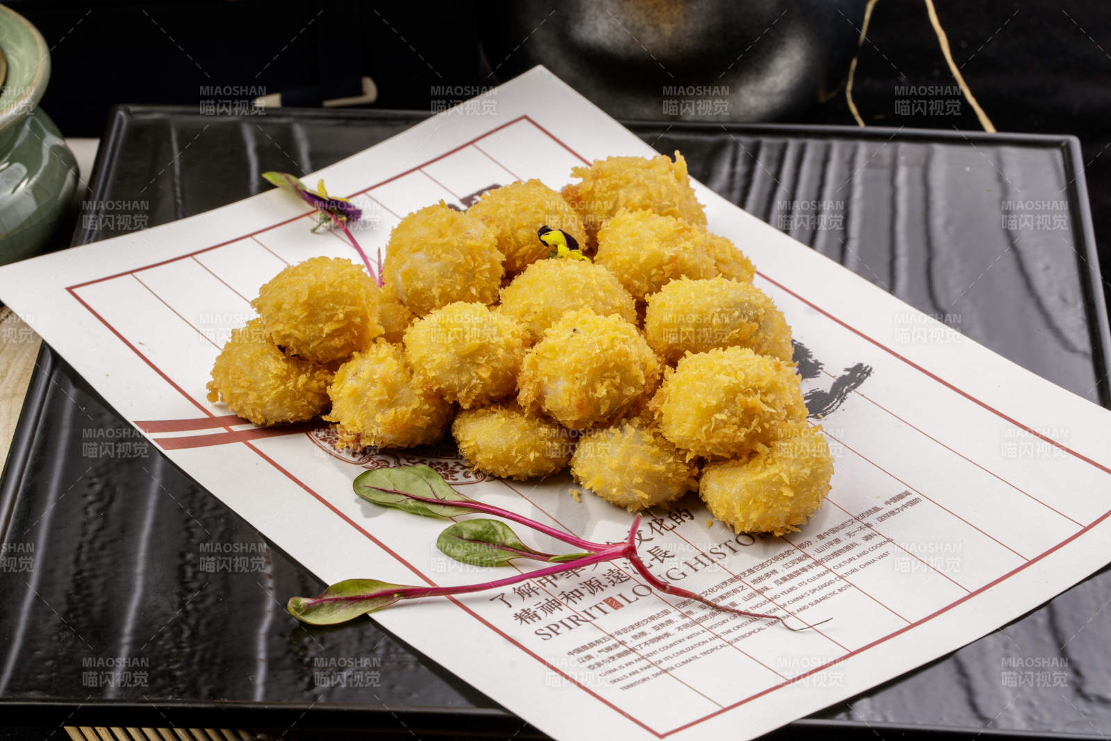 黑色石盘装的油炸苏式小汤圆图片