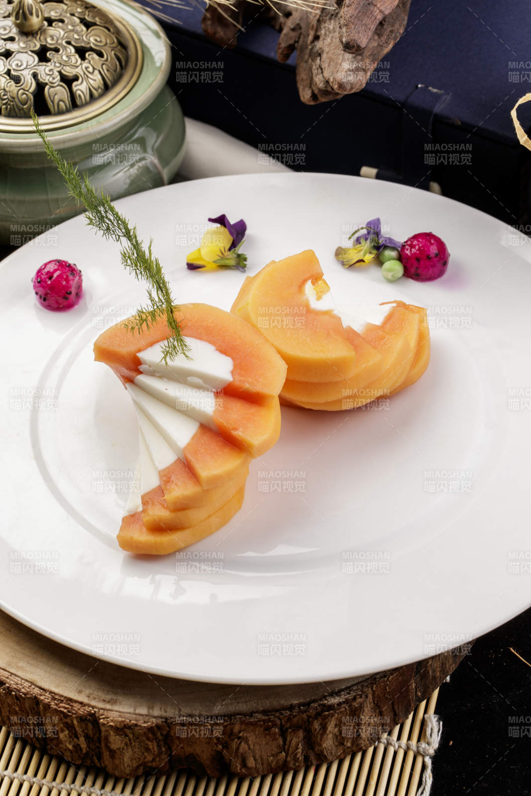 白色圆瓷盘装的木瓜蛋白摆放在樟木砧板上图片