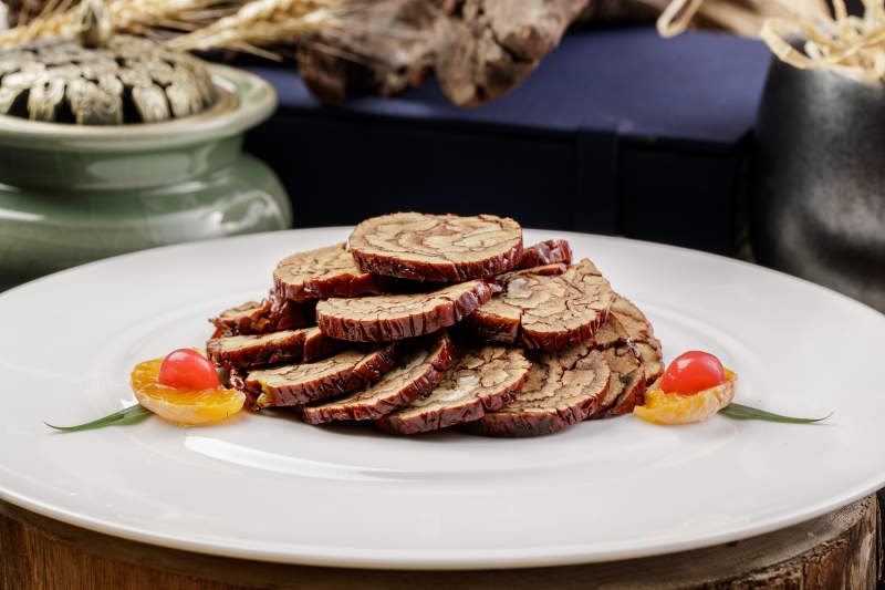 白色圆盘装的红枣核桃片摆放在寿司帘上图片