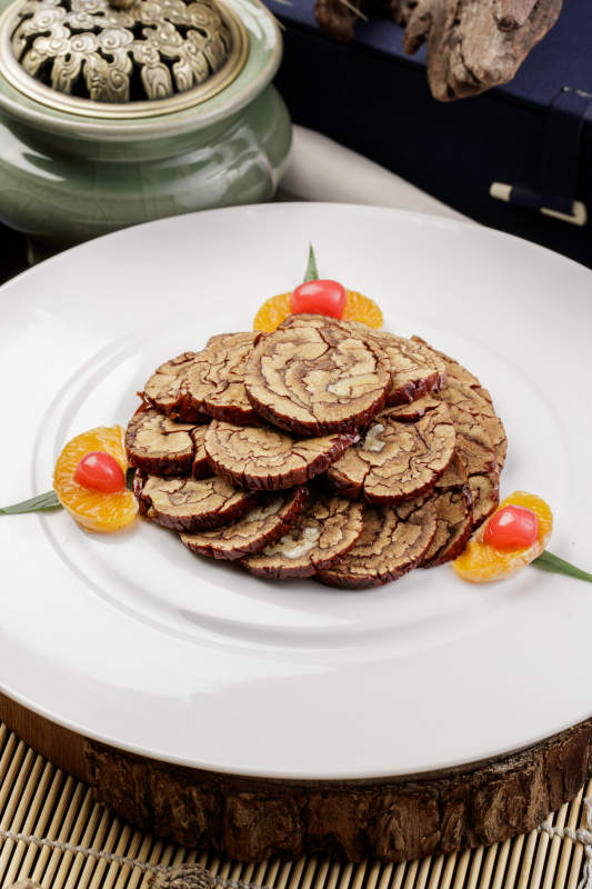 白色圆盘装的红枣核桃片摆放在寿司帘上图片