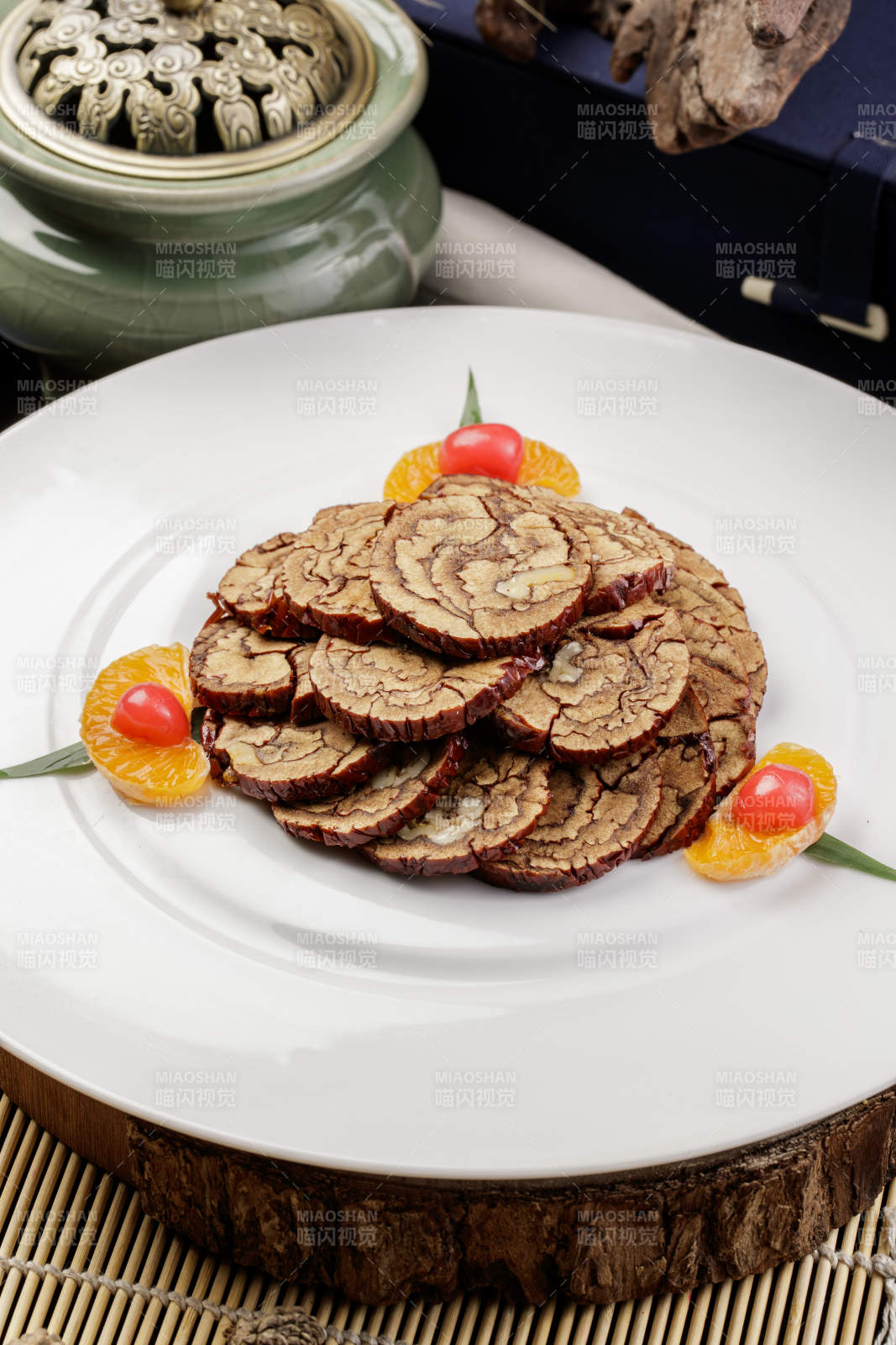 白色圆盘装的红枣核桃片摆放在寿司帘上图片