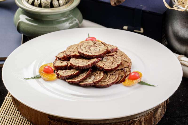 白色圆盘装的红枣核桃片摆放在寿司帘上图片