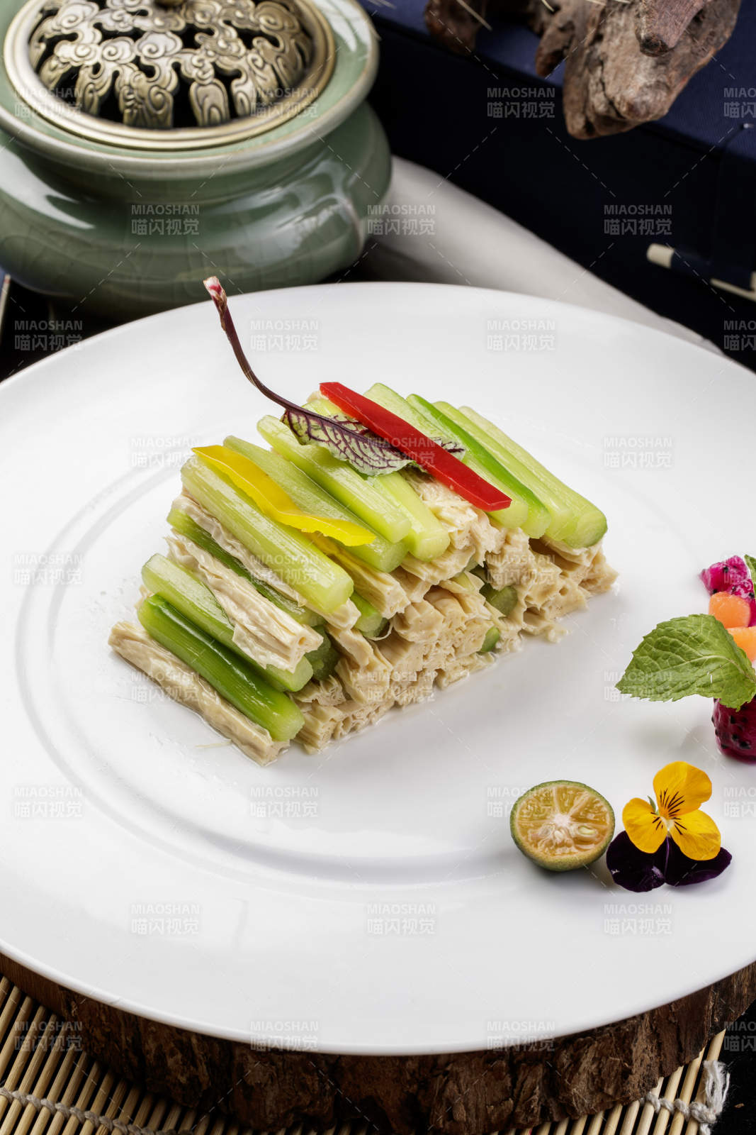 圆形白色瓷盘装的乳瓜腐竹摆放在樟木砧板上图片