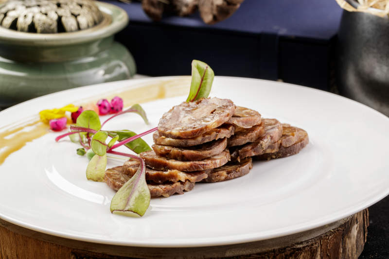 白色瓷盘装的五香牛腱切片图片