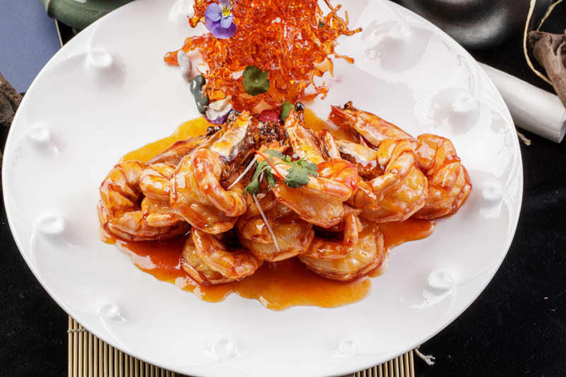 白色圆盘装的花开富贵虾摆放在寿司帘上图片