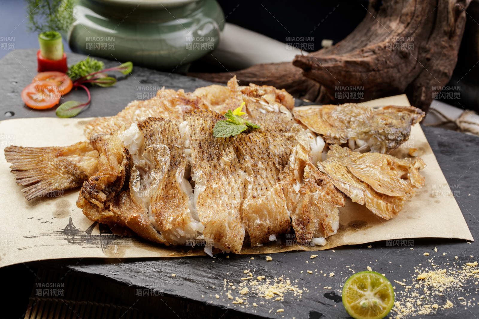 香酥炸高背鲫鱼摆放在黑色背景上图片