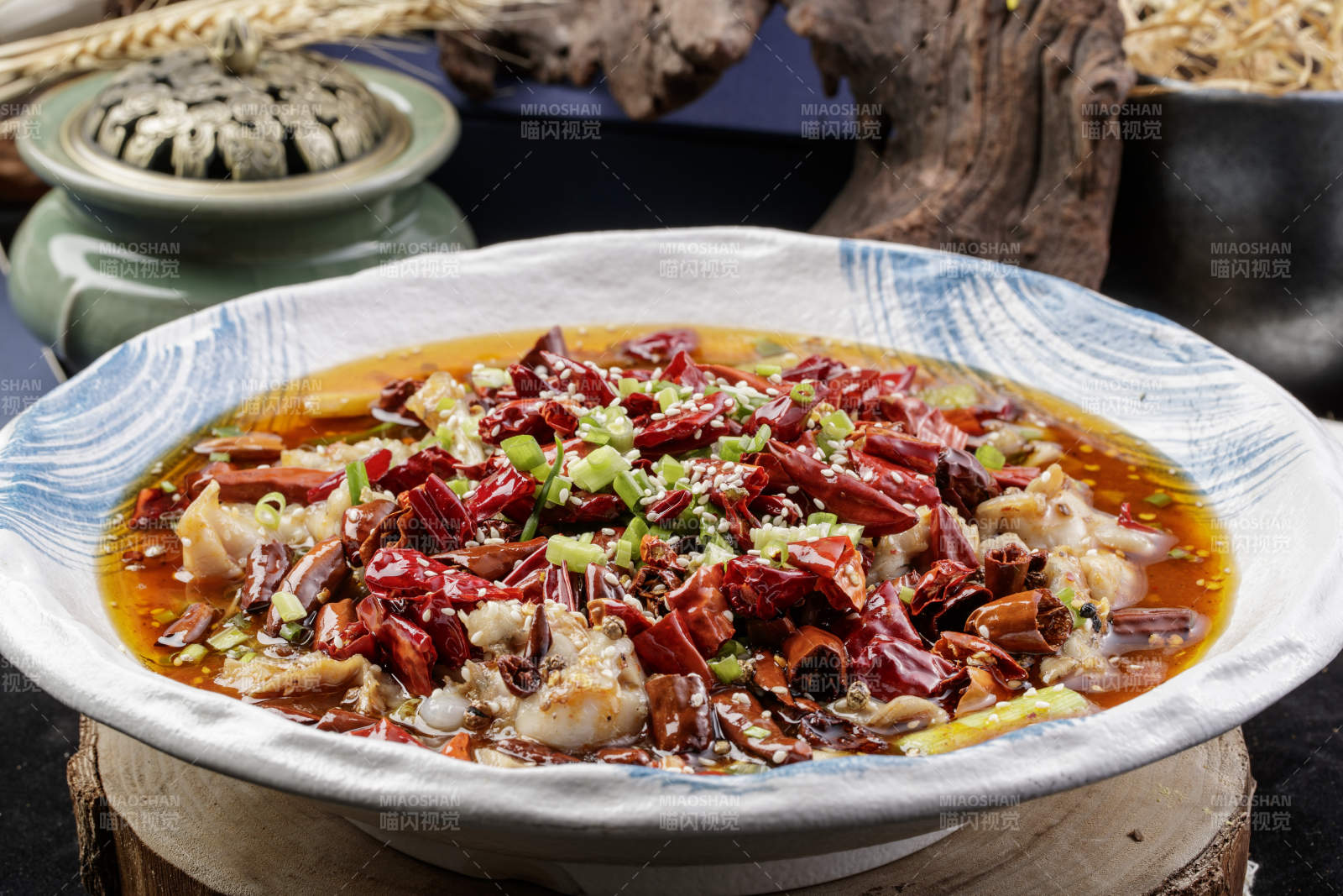 白色花纹盘装的香辣馋嘴蛙摆放在寿司帘上图片