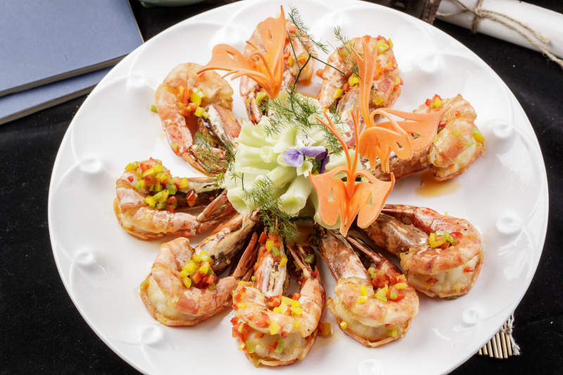 白色瓷盘装的香炸开背大明虾摆放在寿司帘上图片