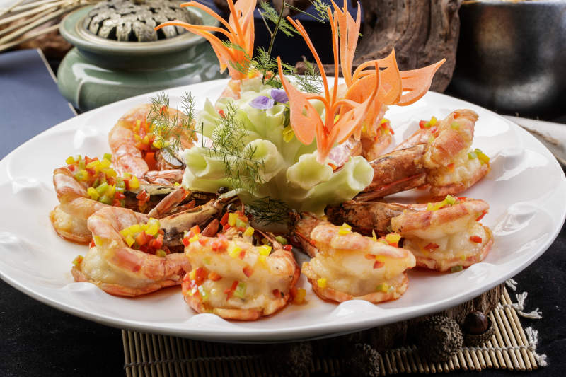 白色瓷盘装的香炸开背大明虾摆放在寿司帘上图片