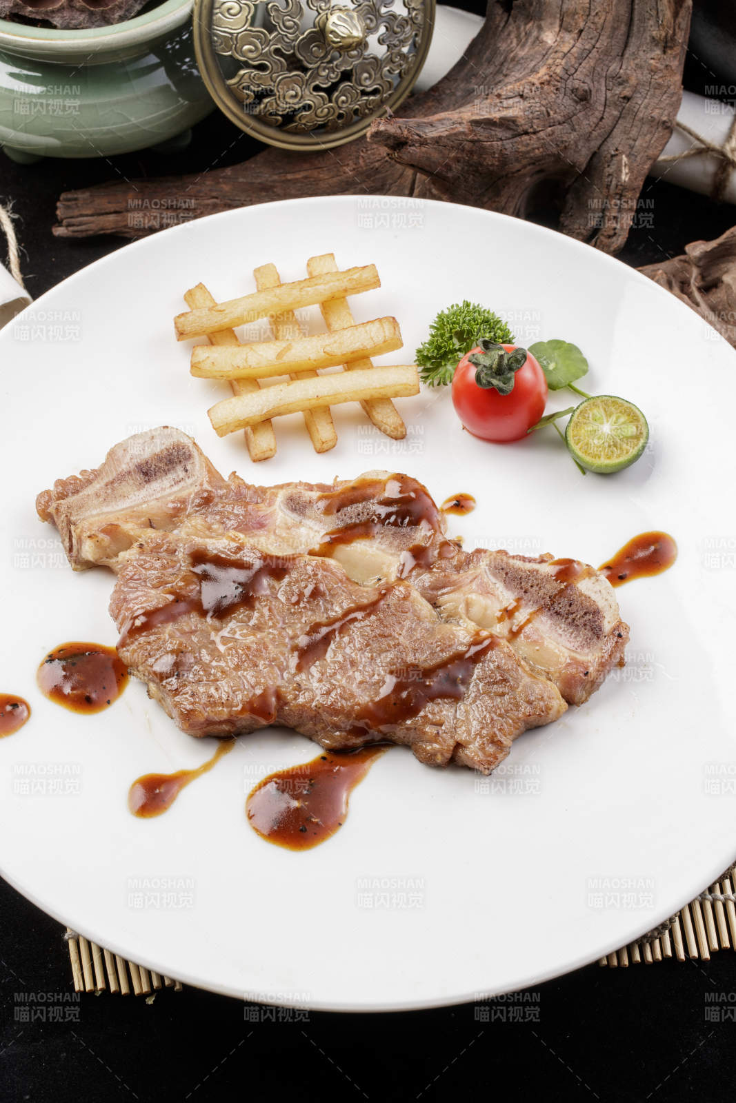 圆形白瓷盘装的香煎牛仔骨摆放在寿司帘上图片