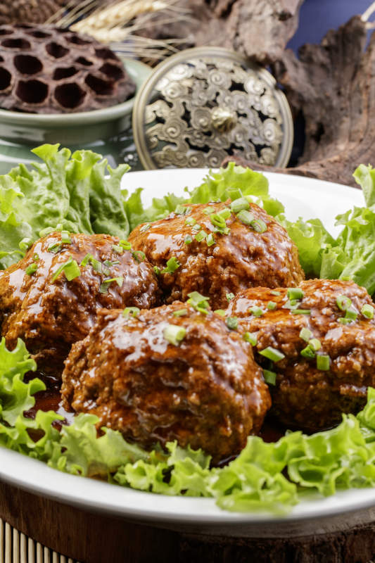 红烧四喜丸子铁狮子头摆放在樟木砧板上图片