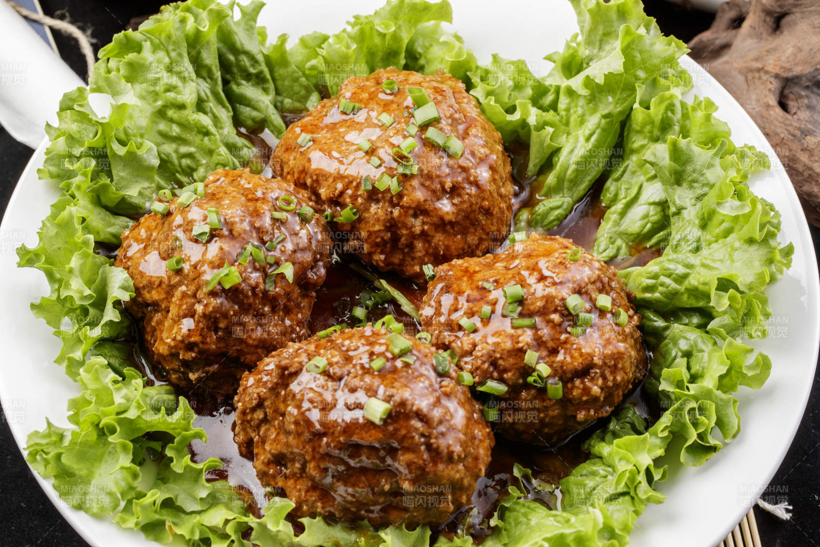 红烧四喜丸子铁狮子头摆放在樟木砧板上图片