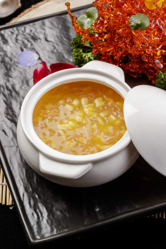 白色汤盅装的木瓜银耳羹摆放在黑色石盘上图片