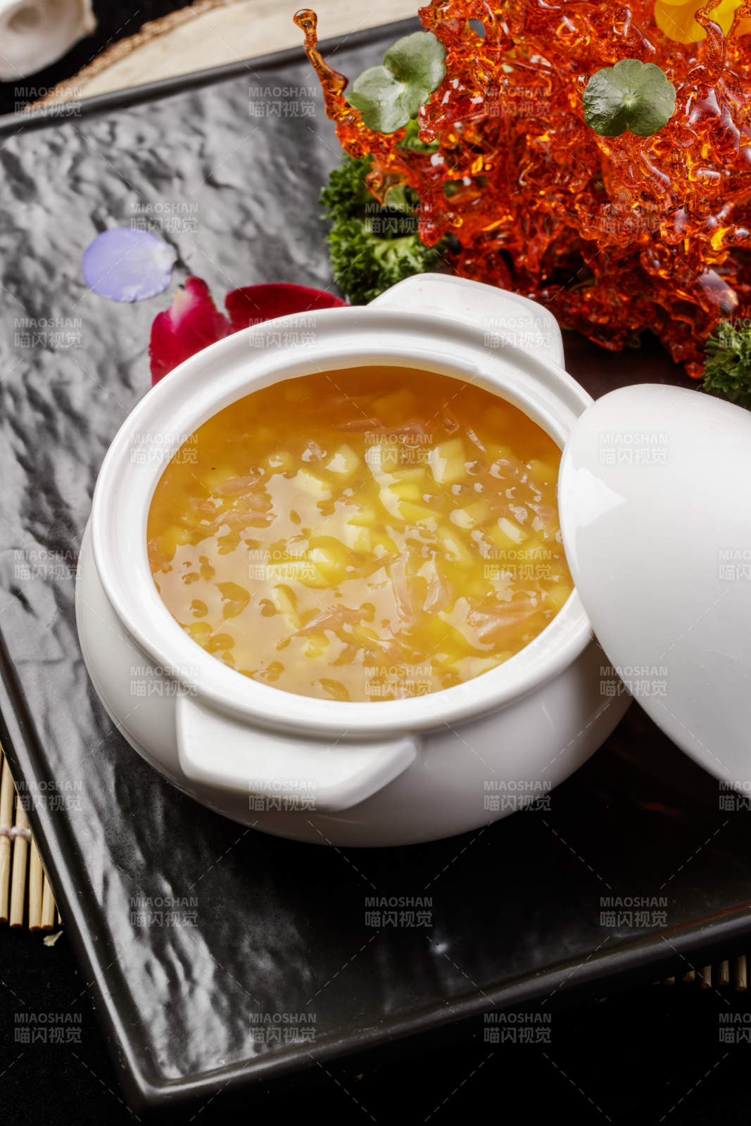 白色汤盅装的木瓜银耳羹摆放在黑色石盘上图片