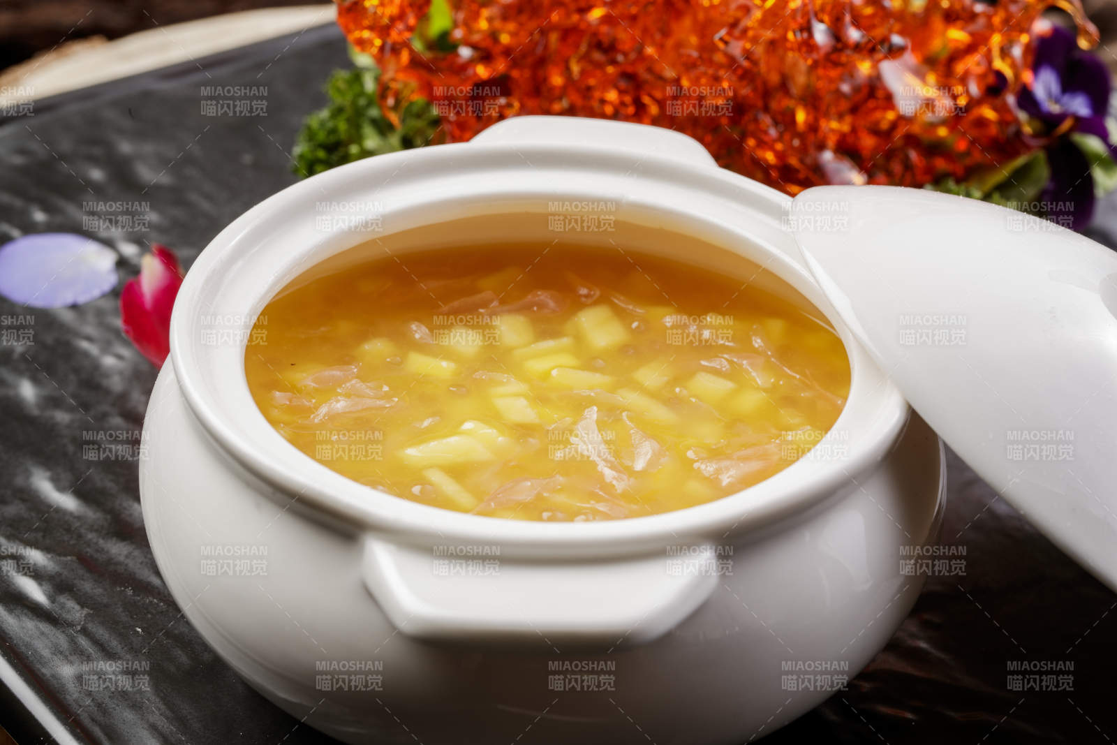 白色汤盅装的木瓜银耳羹摆放在黑色石盘上图片