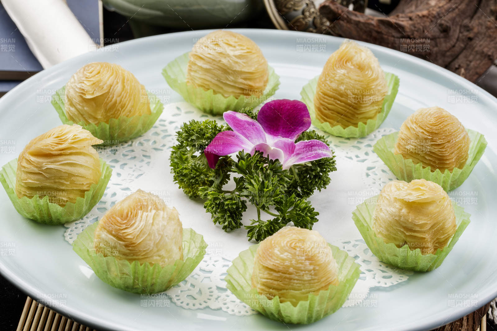 青瓷盘装的木瓜酥摆放在寿司帘上图片