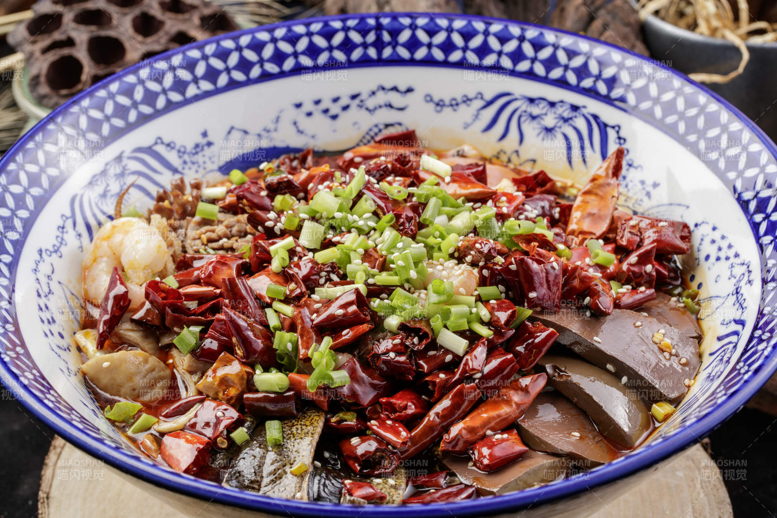 青花瓷盆装的海鲜毛血旺摆放在樟木砧板上图片