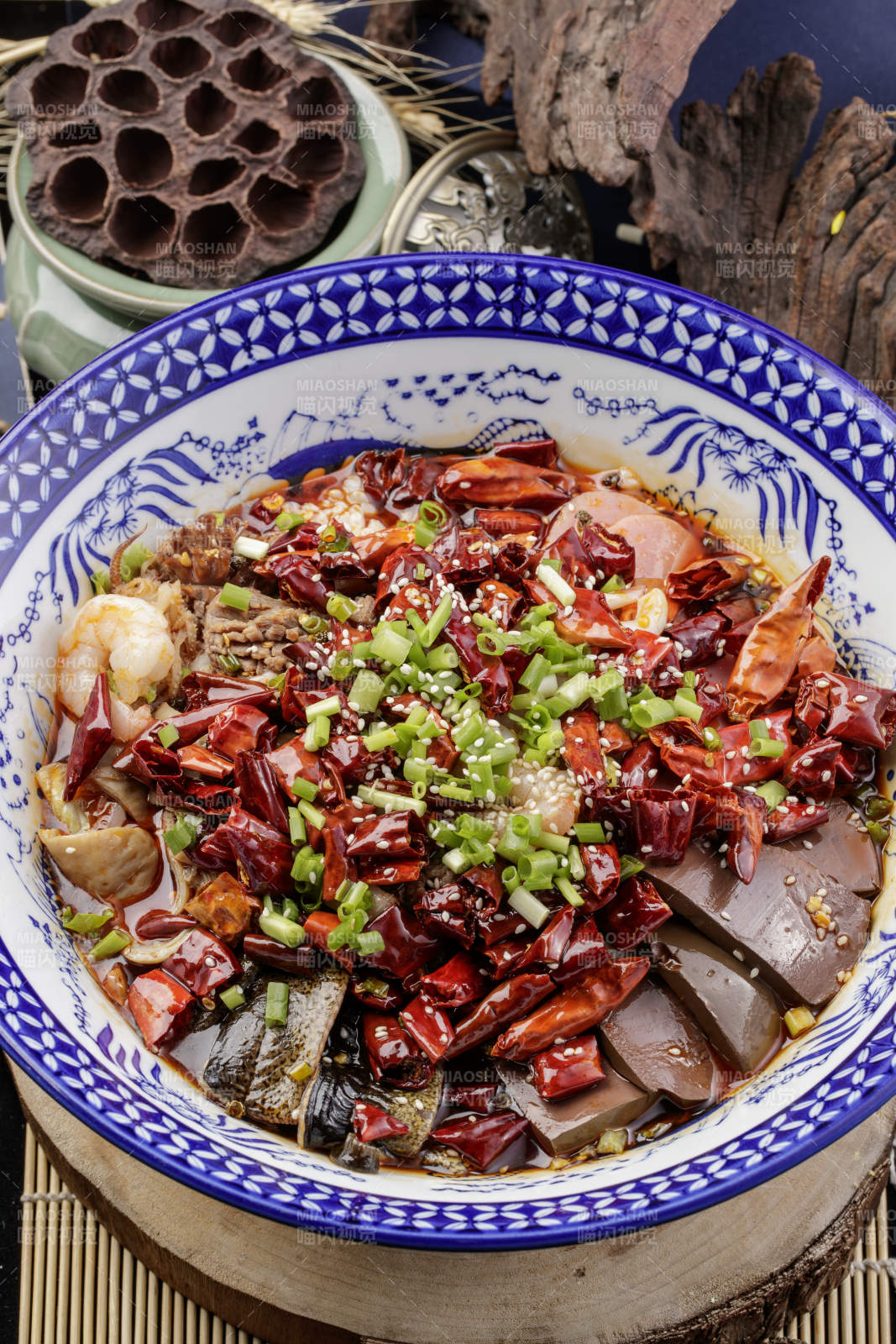 青花瓷盆装的海鲜毛血旺摆放在樟木砧板上图片