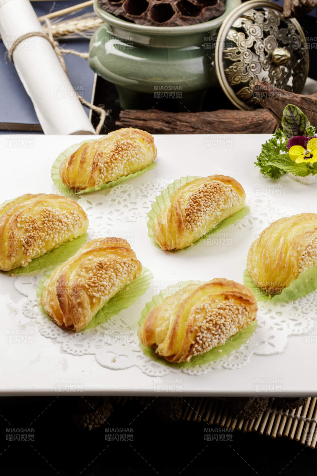 方形瓷盘装的半打榴莲酥摆放在黑色背景上图片