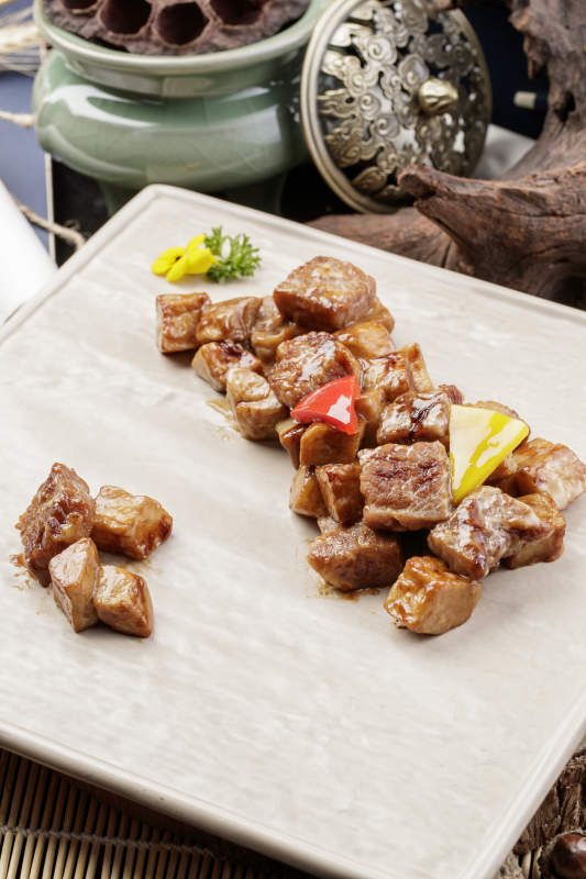 杏鲍菇牛仔粒摆放在樟木砧板上图片