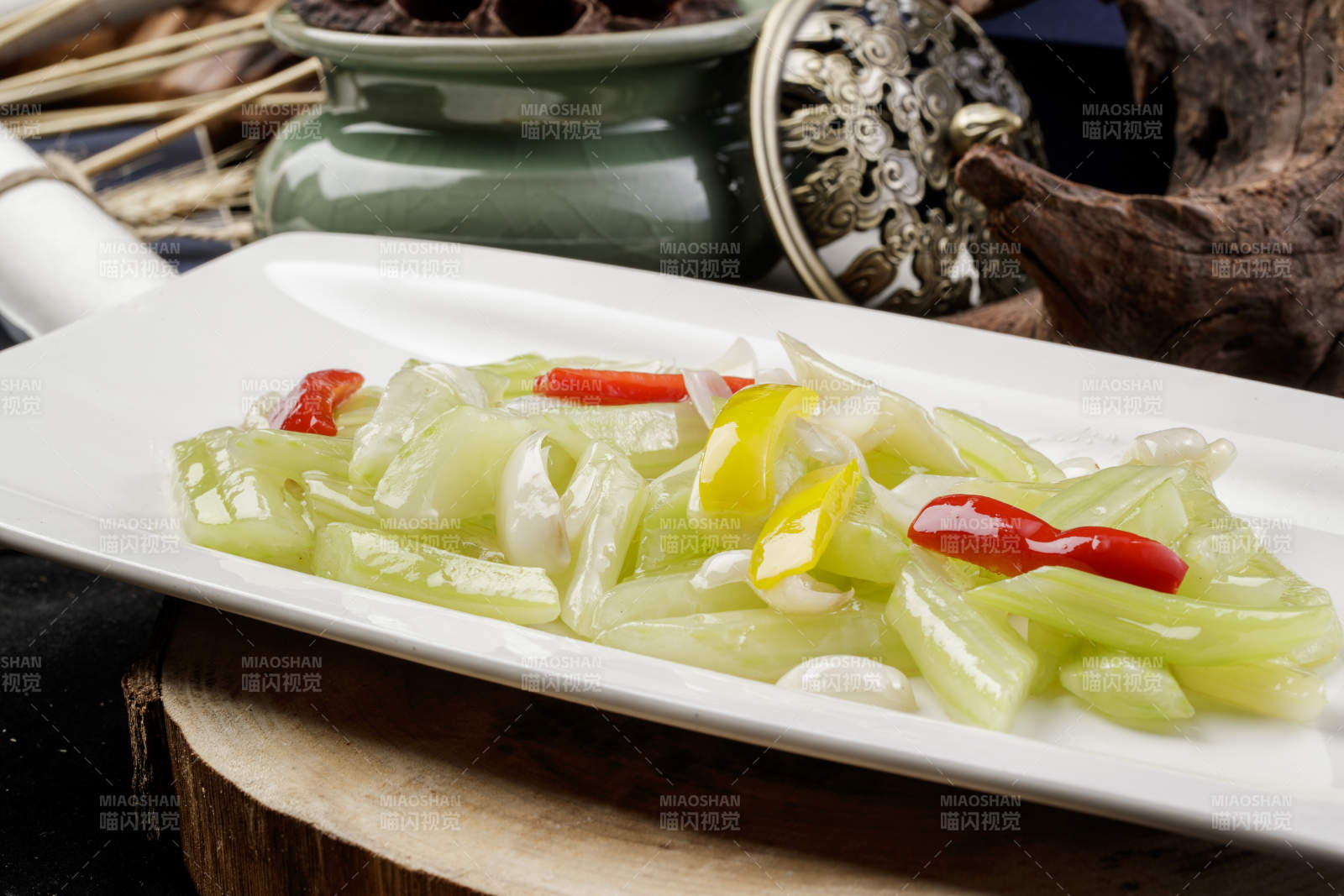 长方形瓷盘装的西芹炒百合摆放在樟木砧板上图片