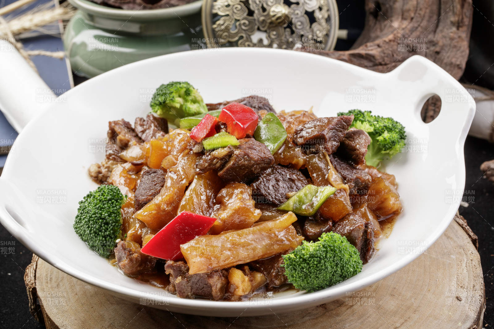 白色耳盘装的牛五花烧蹄筋摆放在樟木砧板上图片