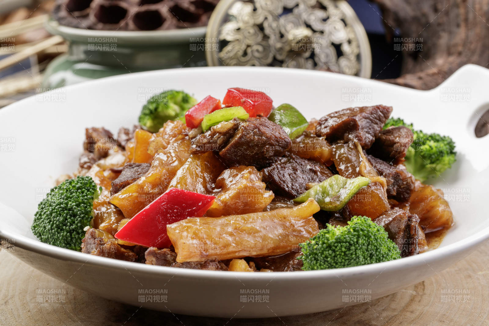 白色耳盘装的牛五花烧蹄筋摆放在樟木砧板上图片