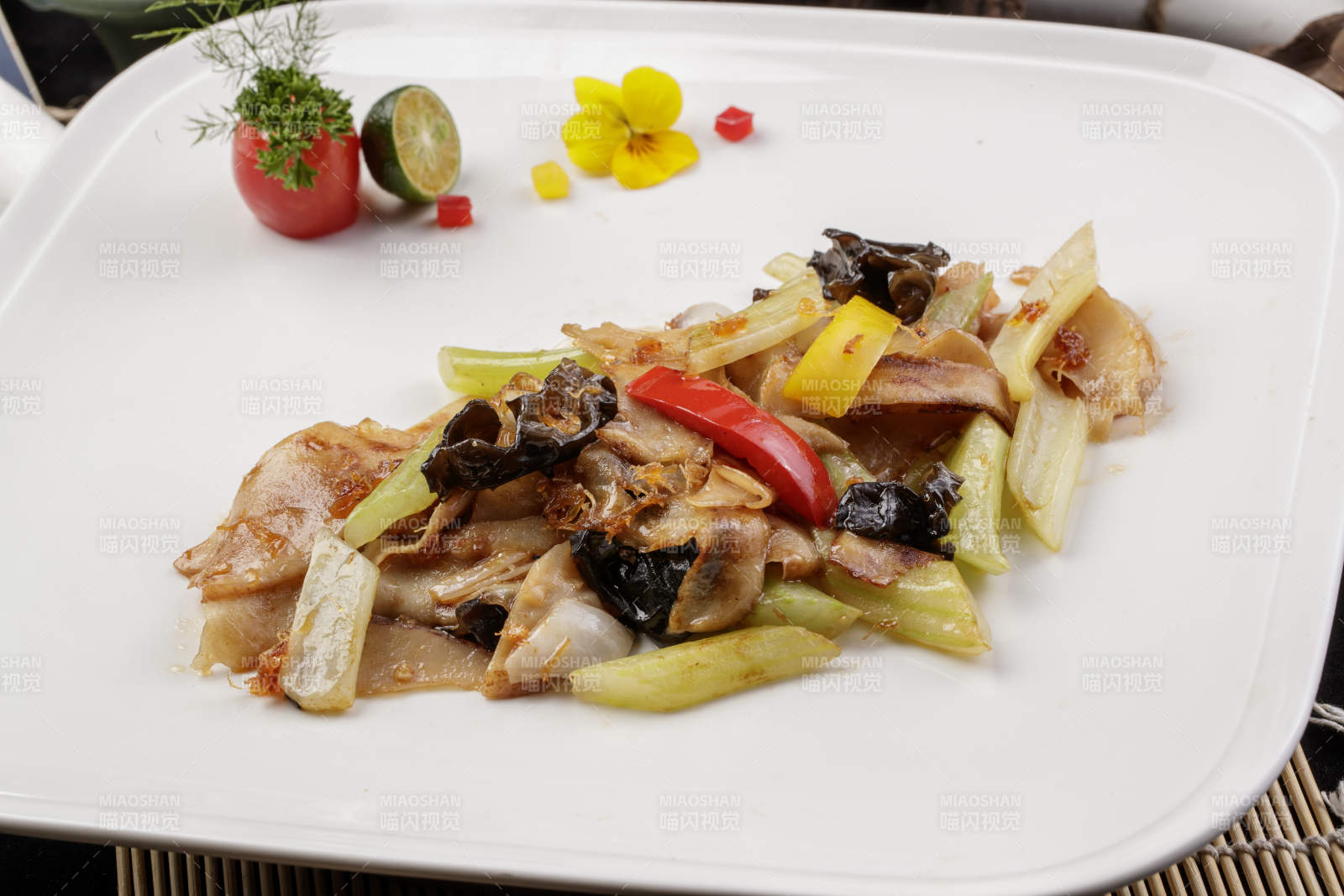 白色瓷盘装的木耳西芹小炒山猪肉图片