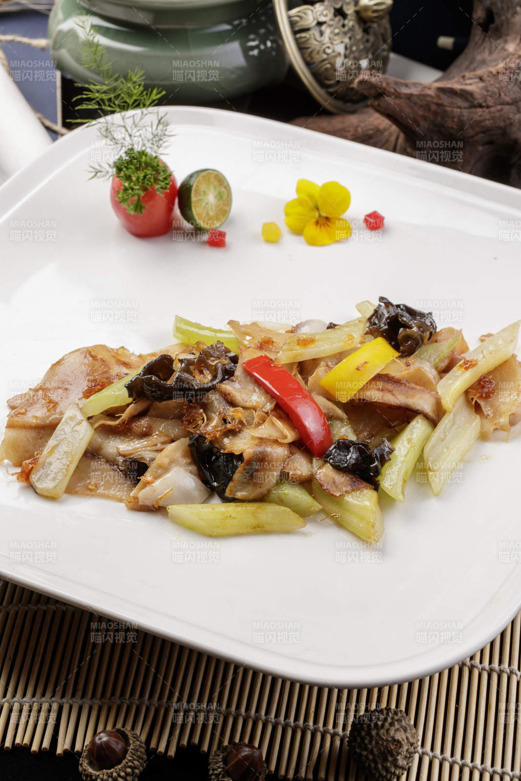 白色瓷盘装的木耳西芹小炒山猪肉图片