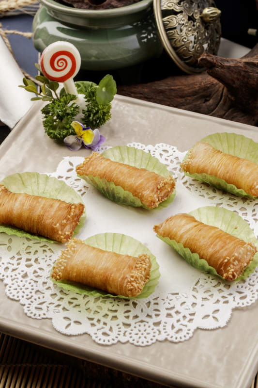 制作精美的泰国榴莲酥摆放在米黄色磁盘上图片