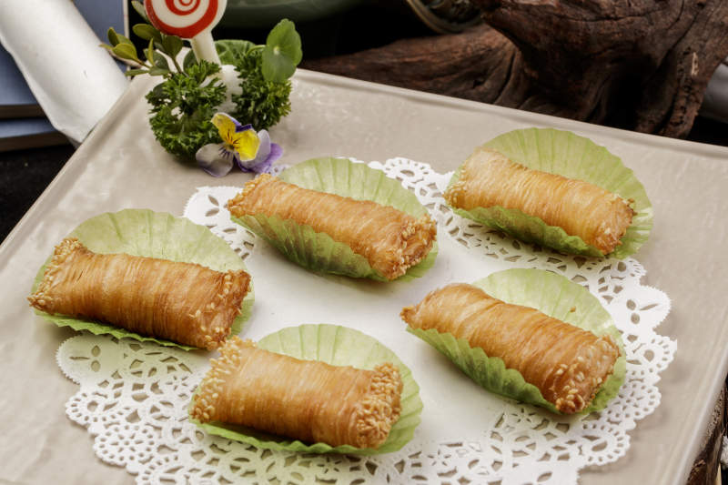 制作精美的泰国榴莲酥摆放在米黄色磁盘上图片