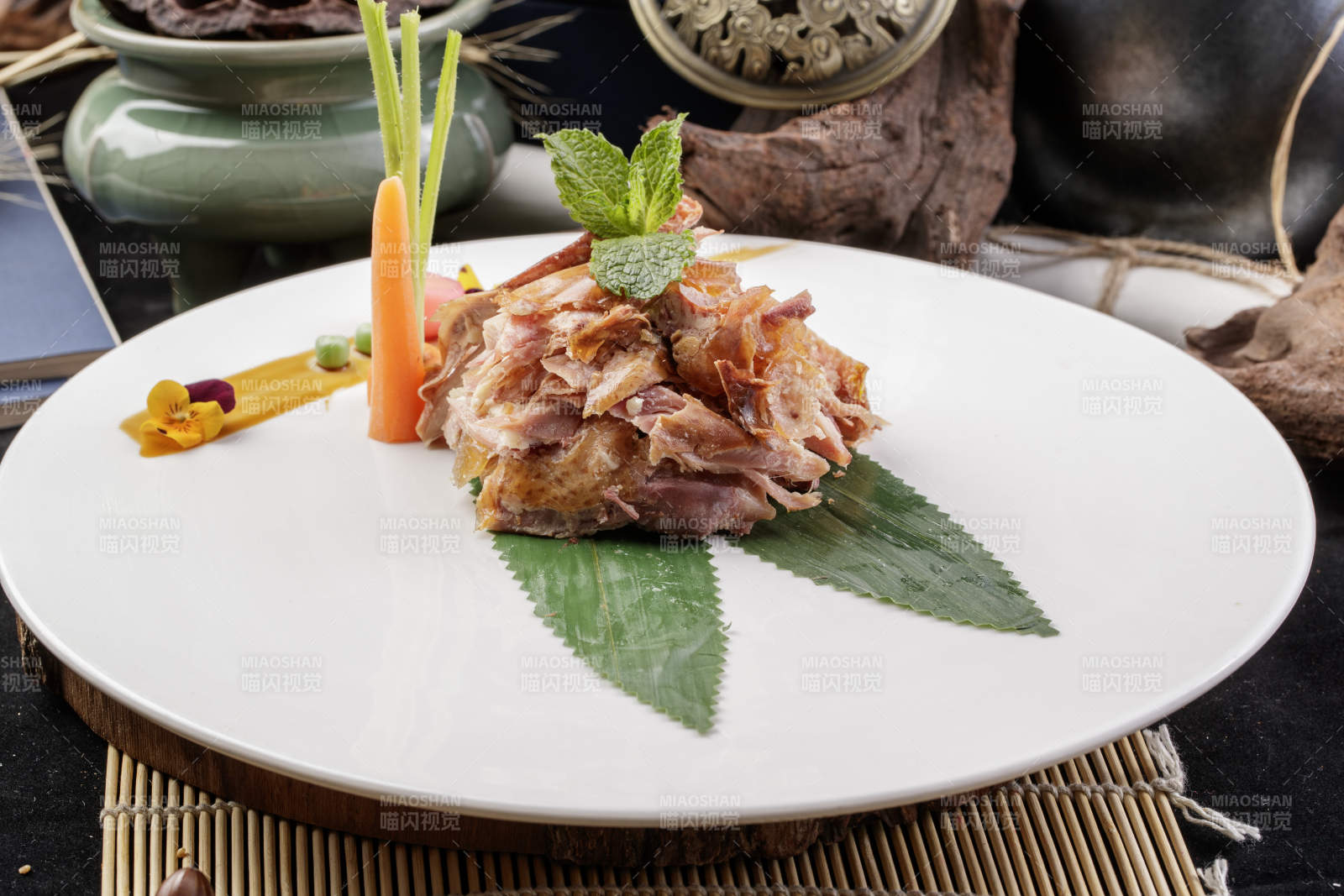 圆形白瓷盘装的风味手撕鸡摆放在寿司帘上图片