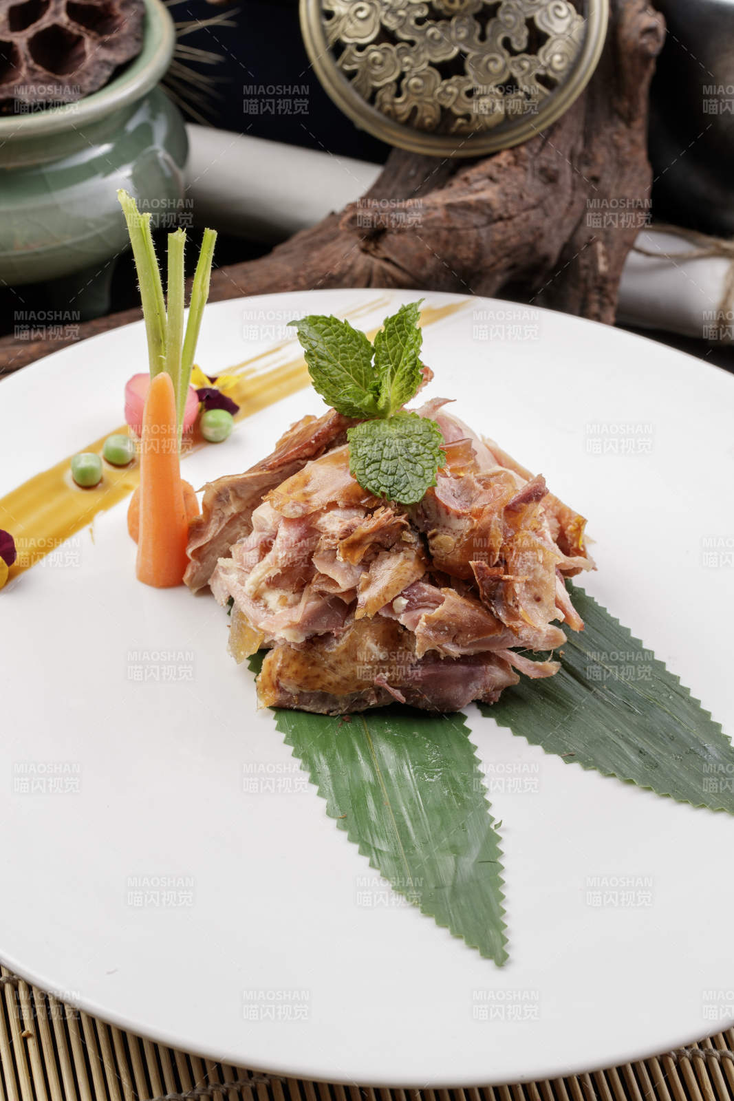 圆形白瓷盘装的风味手撕鸡摆放在寿司帘上图片