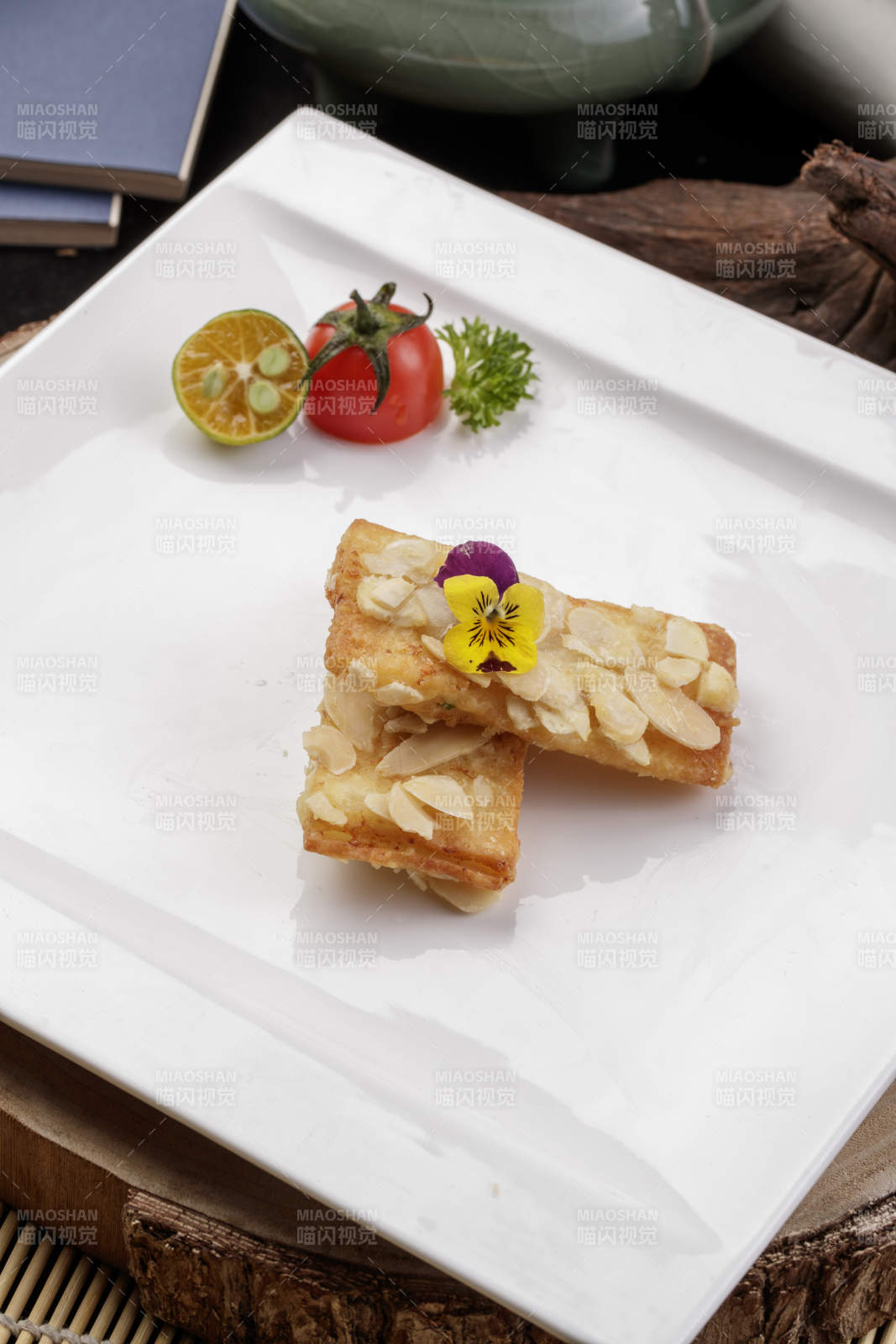 制作精良的北派鱼泥杏仁酥摆放在樟木砧板上图片