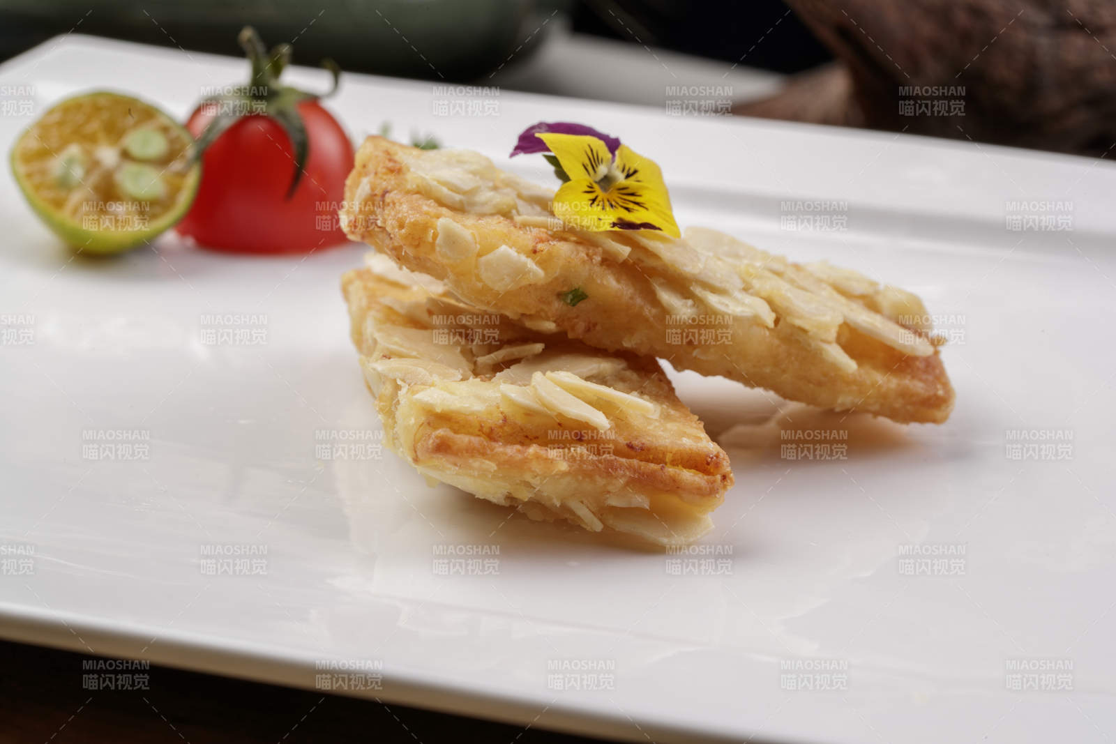 制作精良的北派鱼泥杏仁酥摆放在樟木砧板上图片