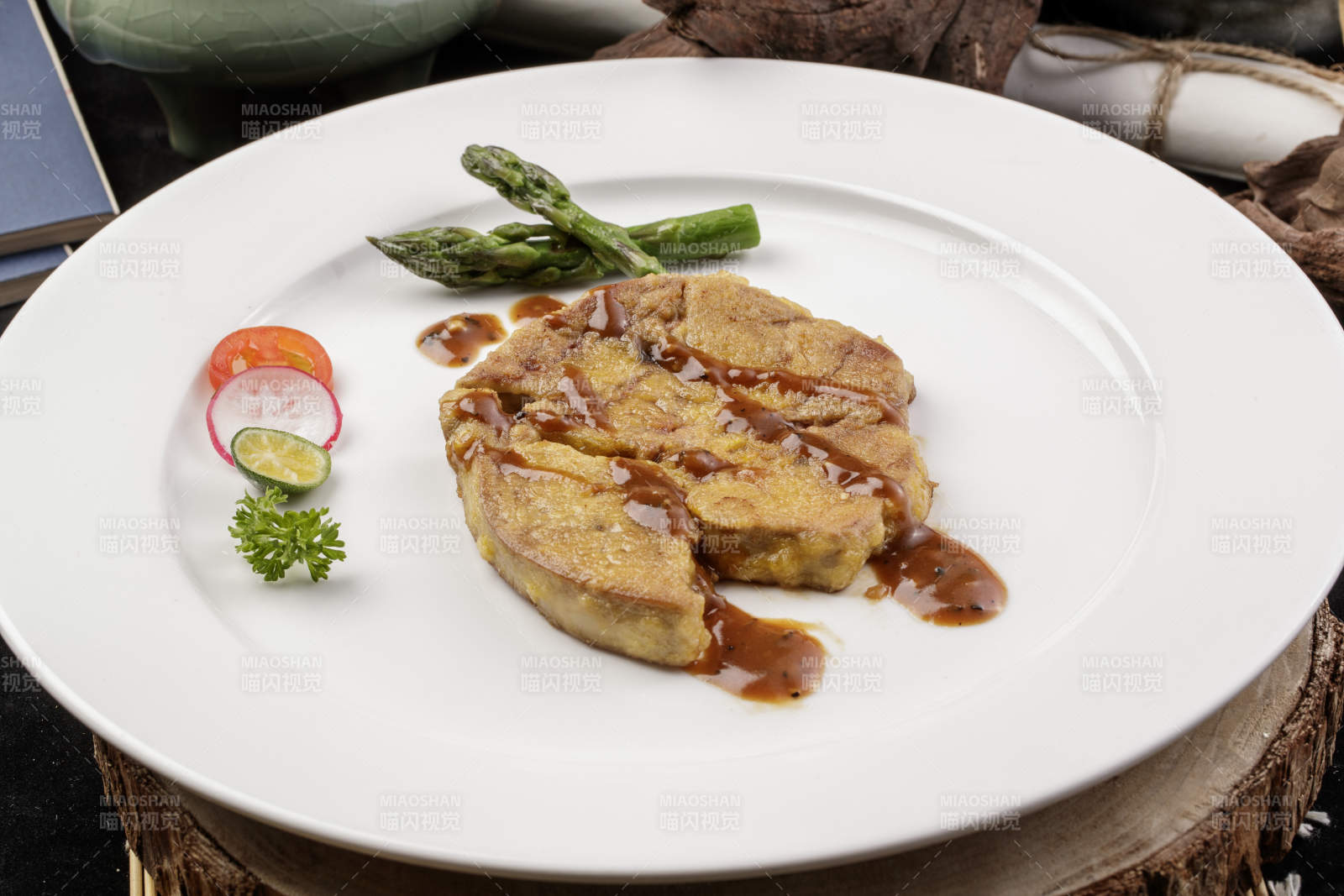 白色圆形瓷盘装的香煎法式鹅肝摆放在樟木砧板上图片